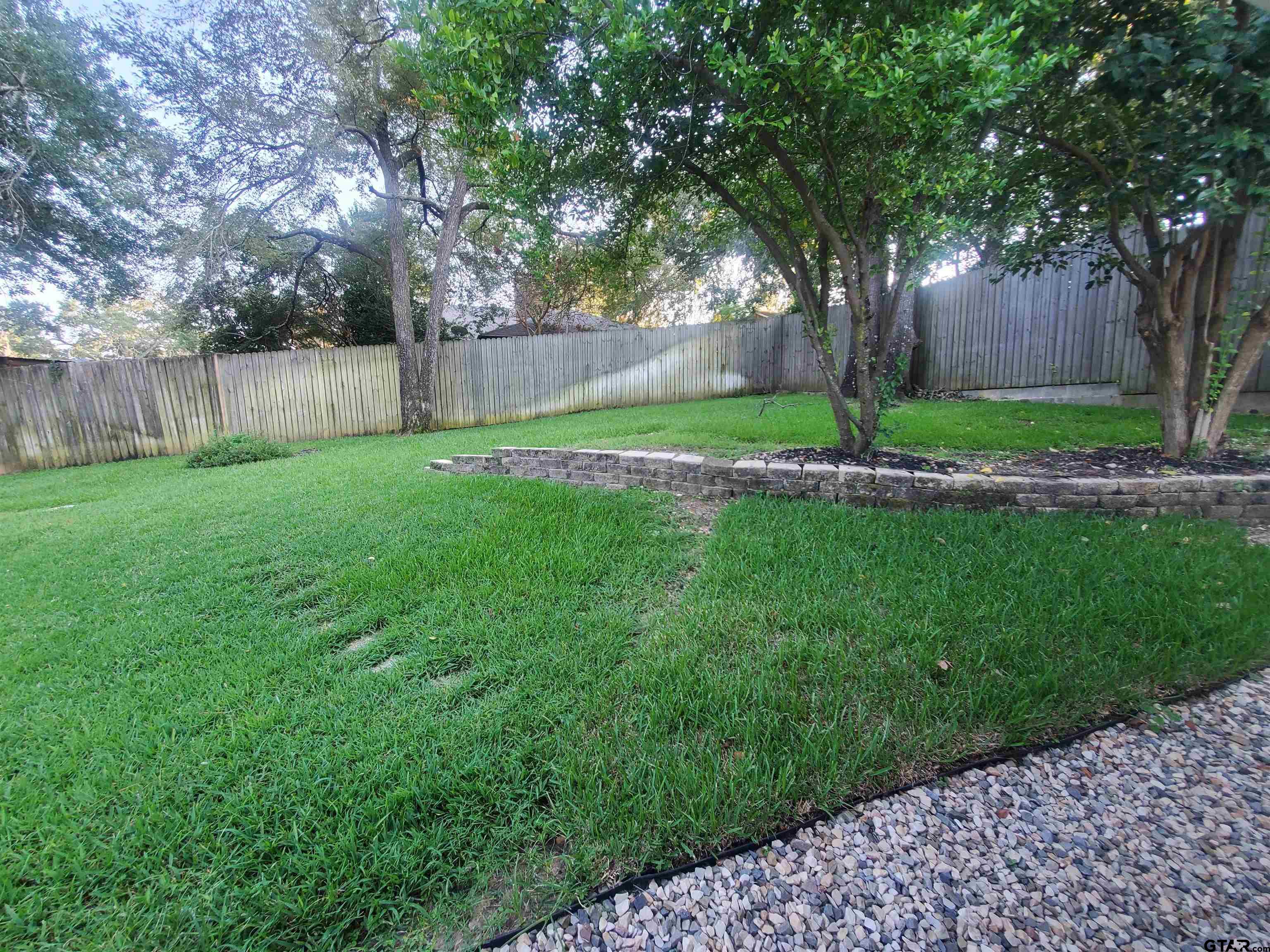 2917 Amy Lane Tyler, TX 75701 - Photo 35 of 36 a view of a yard with a large tree and wooden fence