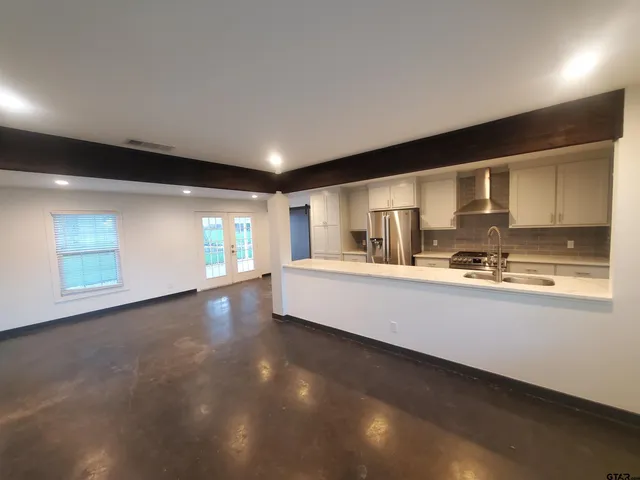 a large kitchen with kitchen island granite countertop a sink and cabinets