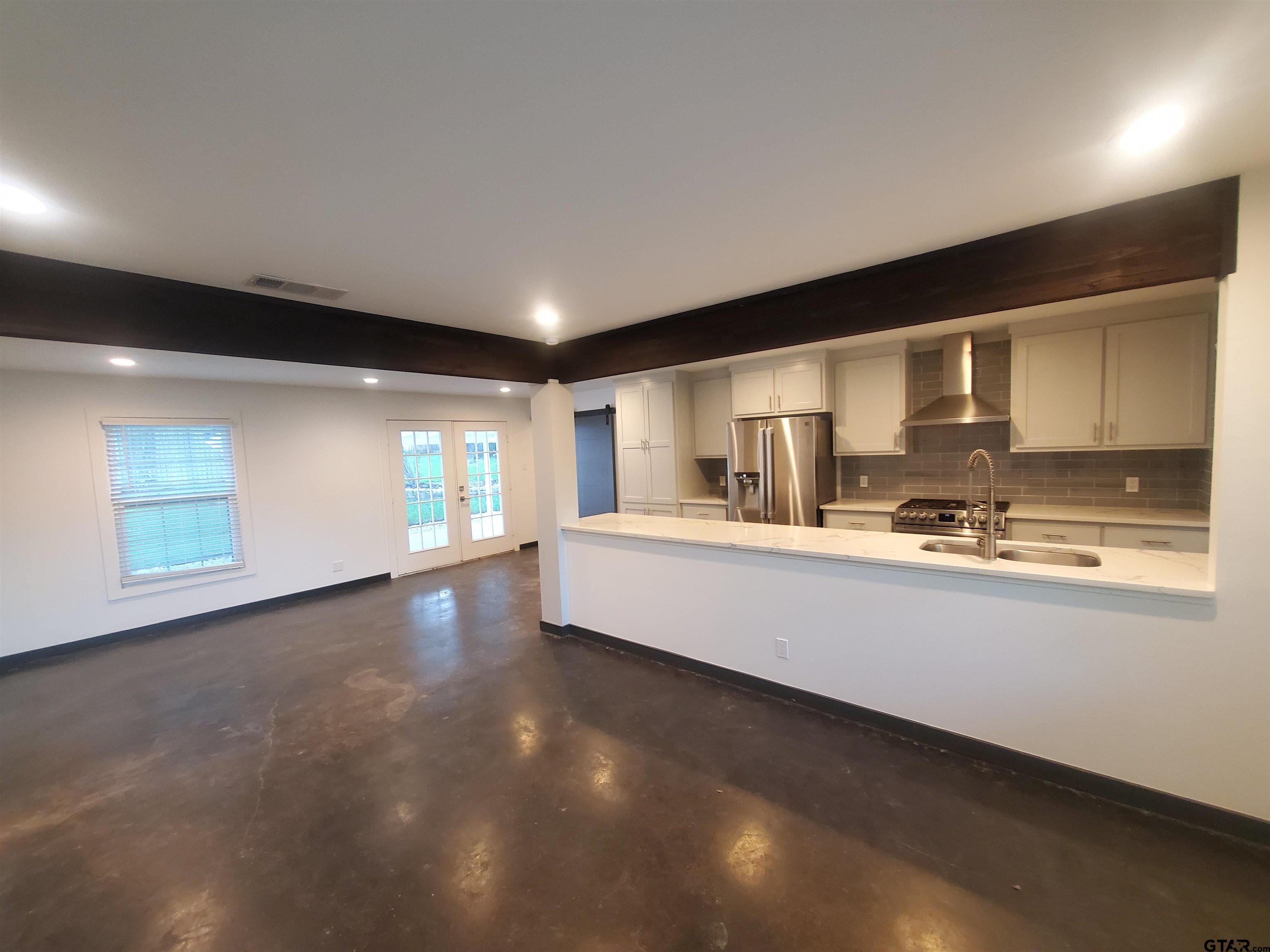 2917 Amy Lane Tyler, TX 75701 - Photo 7 of 36 a large kitchen with kitchen island granite countertop a sink and cabinets