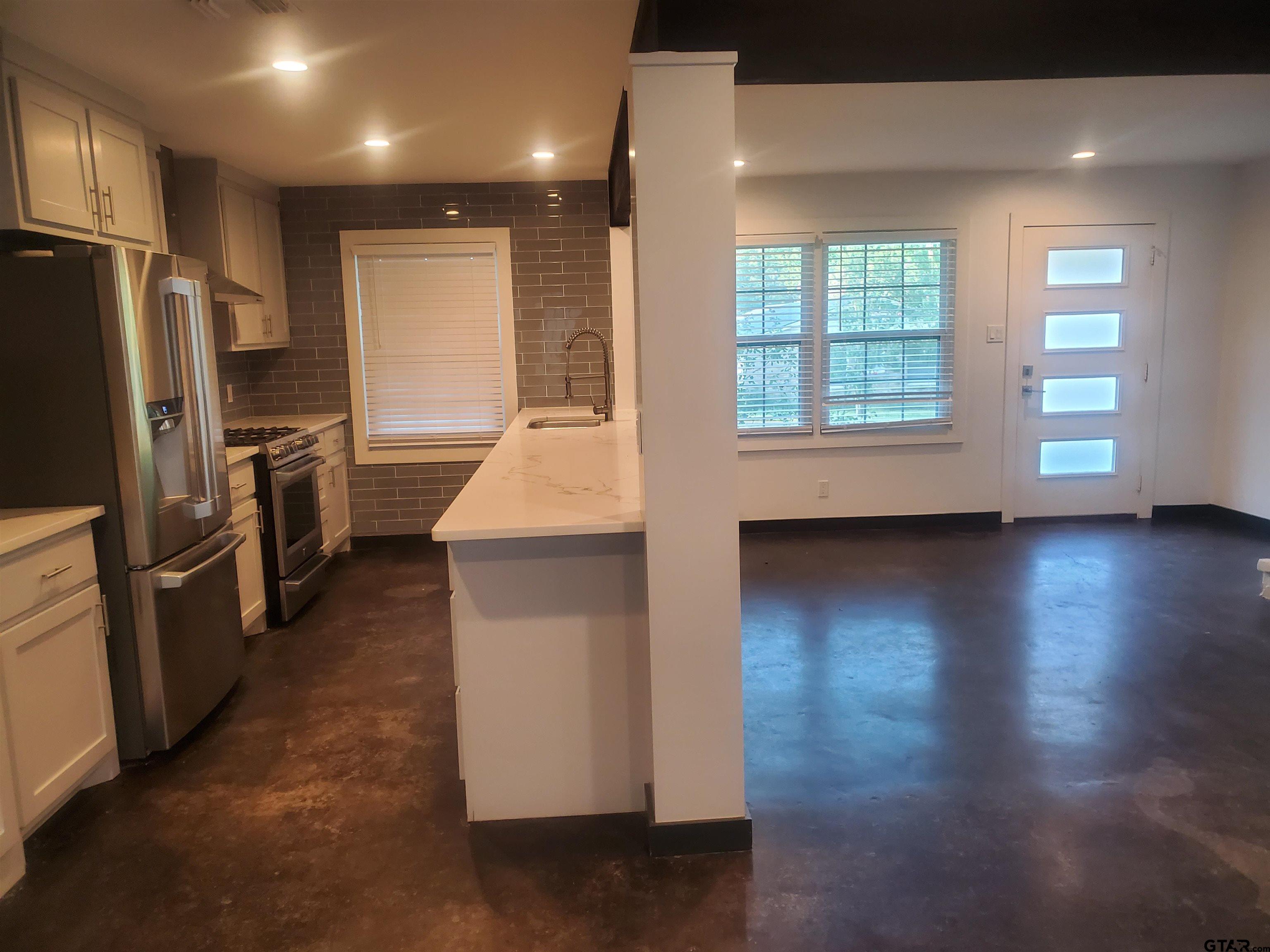 2917 Amy Lane Tyler, TX 75701 - Photo 10 of 36 a kitchen with wooden floor and stainless steel appliances