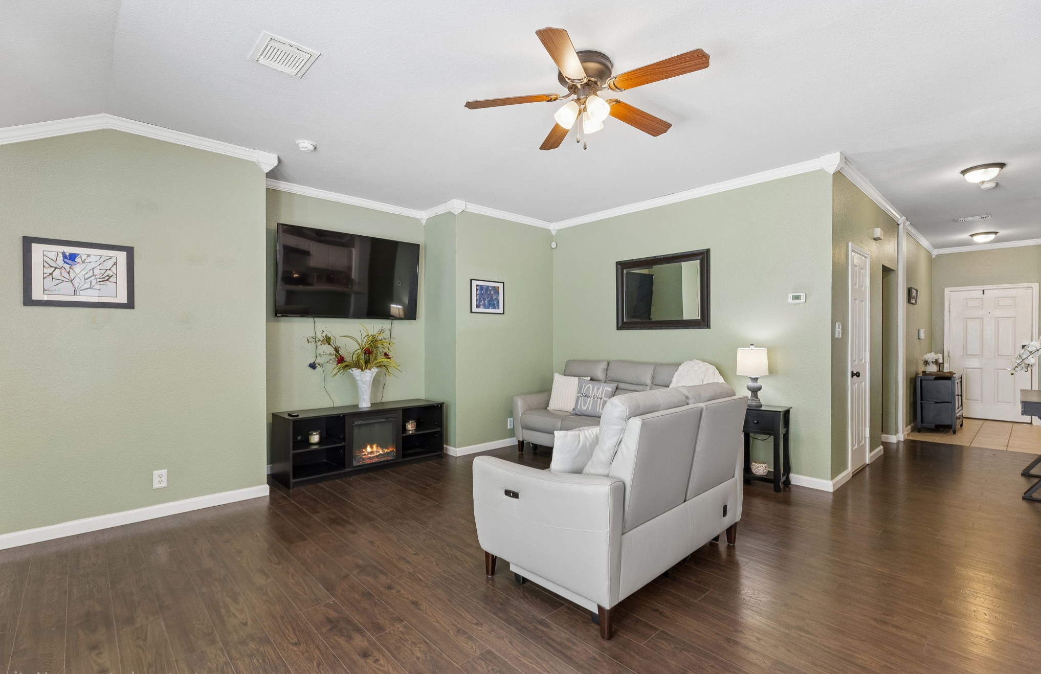 159 Invierno Street Kyle, TX 78640 - Photo 2 of 40 Inside, crown molding and wood-look vinyl flooring give the main living areas a fresh, easygoing feel.