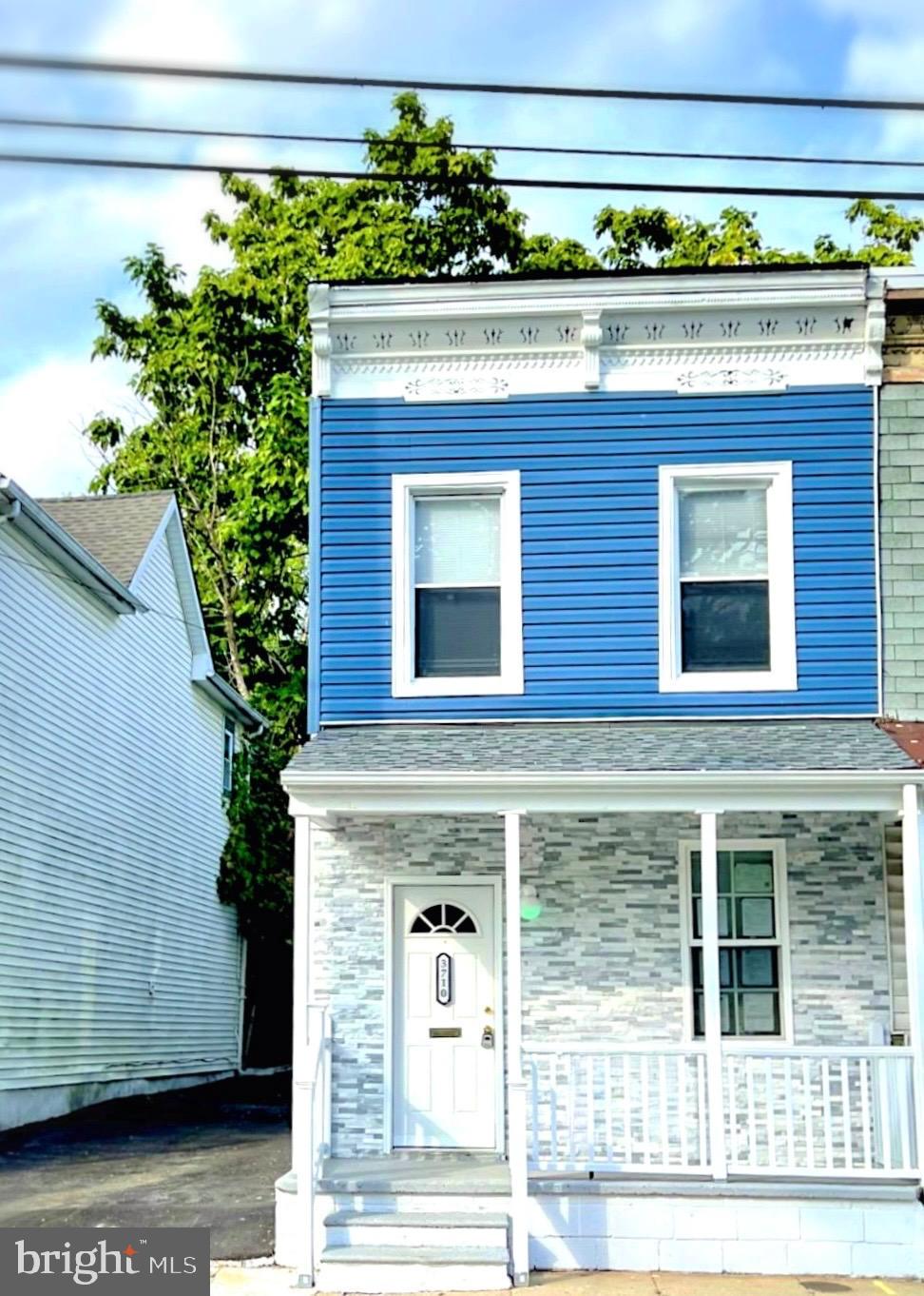 a front view of a building with a garden and plants