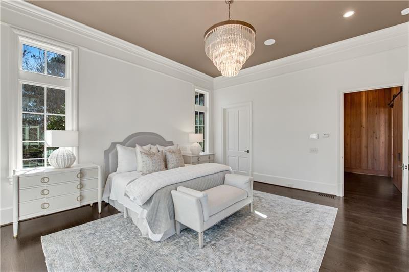 560 Lost River Bend Milton, GA 30004 - Photo 25 of 62 a bedroom with a large bed and a chandelier