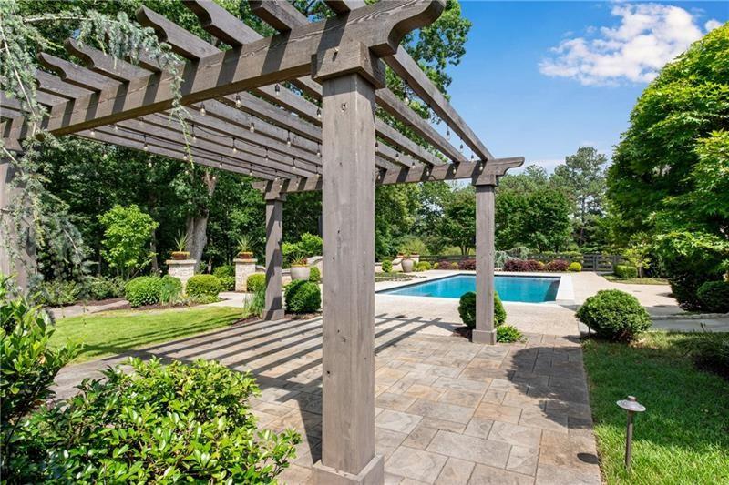 560 Lost River Bend Milton, GA 30004 - Photo 56 of 62 a view of a patio with table and chairs potted plants with wooden floor and fence