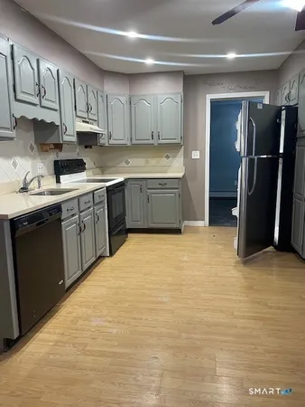 a kitchen with stainless steel appliances granite countertop a refrigerator and a stove top oven