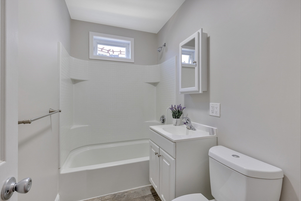 24 Bentley Street, Unit 1 Boston, MA 02135 - Photo 5 of 21 a bathroom with a toilet sink and a bathtub