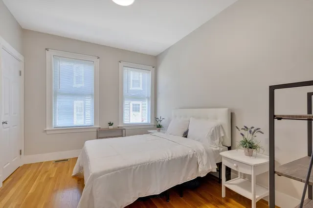 a bedroom with a bed and windows