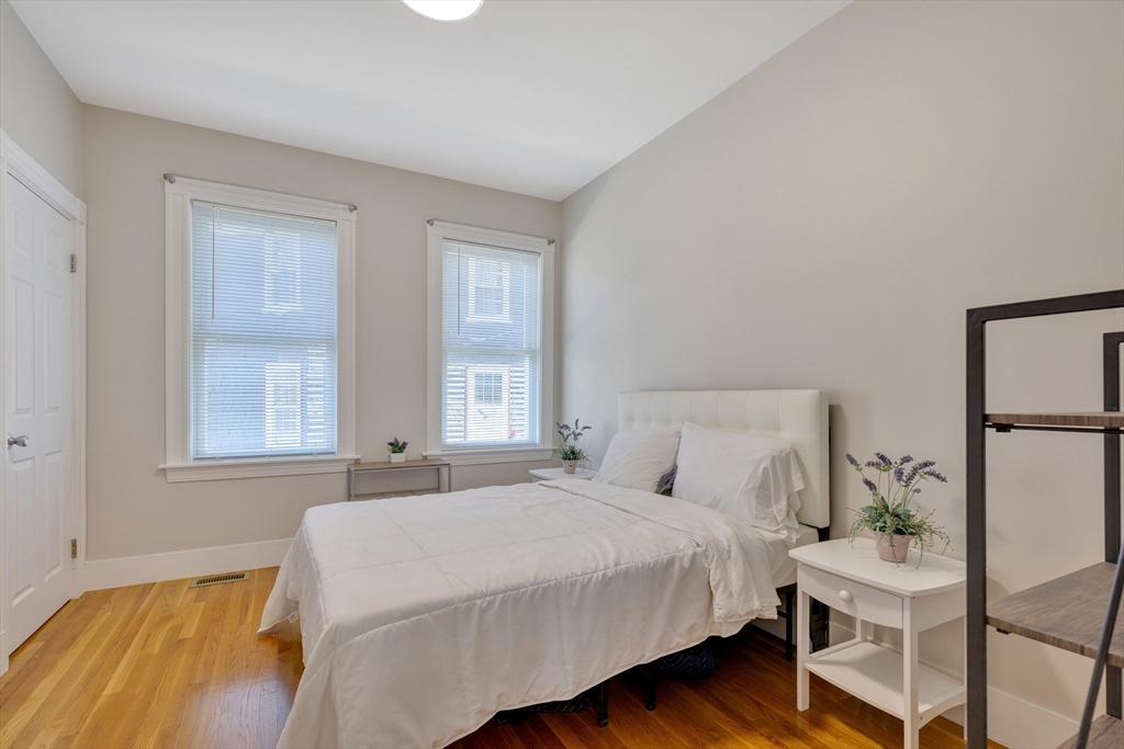 24 Bentley Street, Unit 1 Boston, MA 02135 - Photo 8 of 21 a bedroom with a bed and windows
