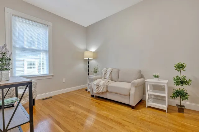 a bedroom with a bed and a potted plant on the dresser