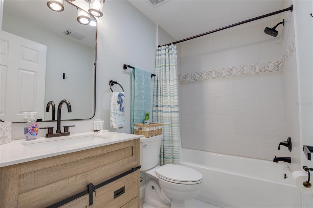 448 Locklie Street Dunedin, FL 34698 - Photo 19 of 51 a bathroom with a sink mirror toilet and bathtub