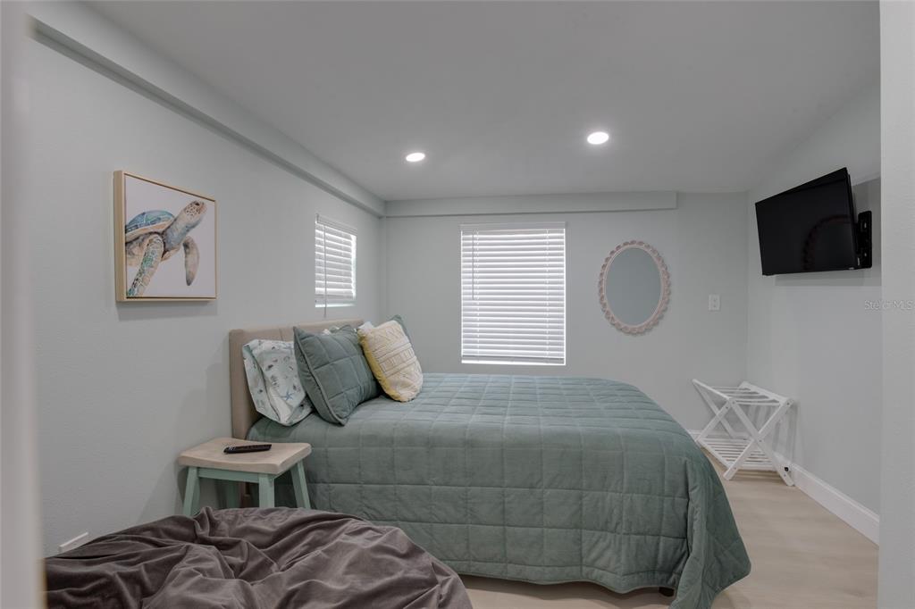 448 Locklie Street Dunedin, FL 34698 - Photo 22 of 51 a bedroom with a bed and a flat screen tv