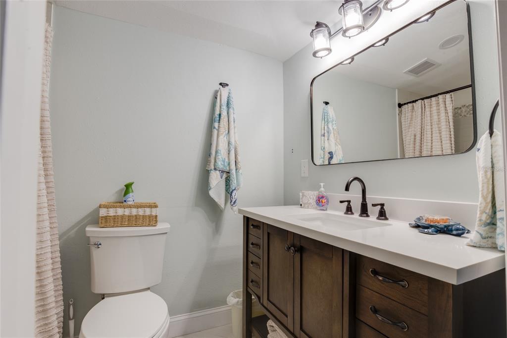 448 Locklie Street Dunedin, FL 34698 - Photo 25 of 51 a bathroom with a sink vanity mirror and toilet