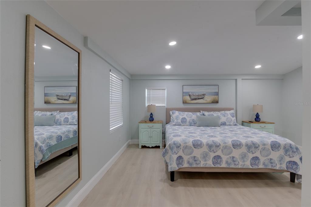 448 Locklie Street Dunedin, FL 34698 - Photo 28 of 51 a bedroom with a large bed and a chandelier