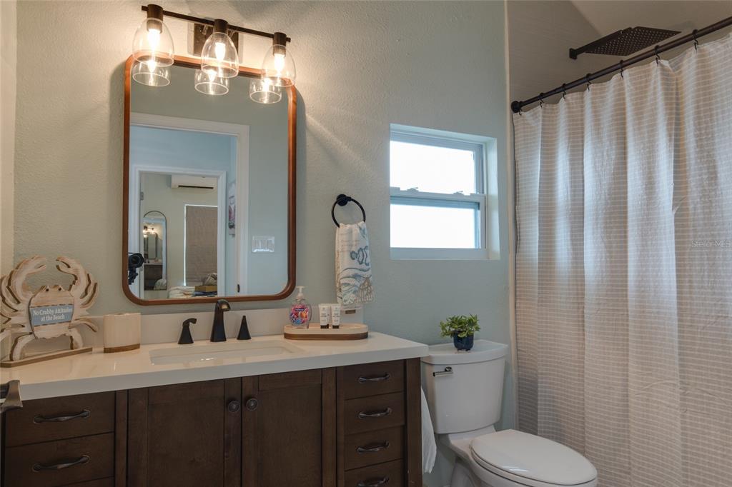 448 Locklie Street Dunedin, FL 34698 - Photo 45 of 51 a bathroom with a toilet a sink and mirror