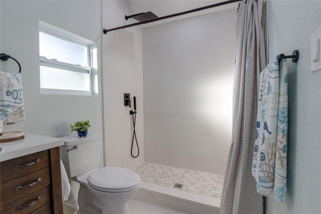 448 Locklie Street Dunedin, FL 34698 - Photo 46 of 51 a bathroom with a shower a toilet and a sink