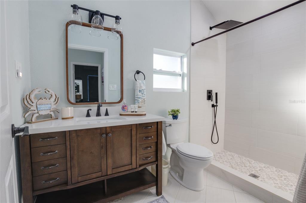 448 Locklie Street Dunedin, FL 34698 - Photo 47 of 51 a bathroom with a toilet sink and mirror