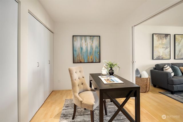 a view of a workspace room with furniture and window