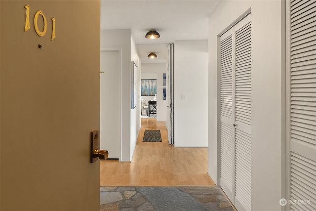 a view of a hallway with wooden floor and closet
