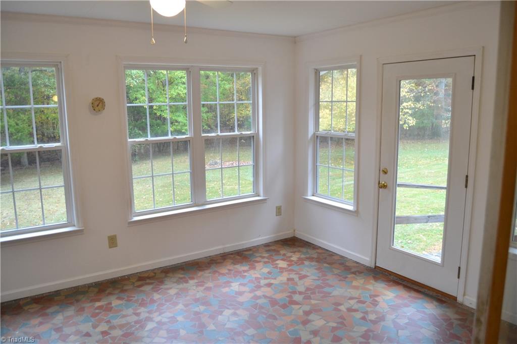 4758 Old Greensboro Road Randleman, NC 27317 - Photo 5 of 23 Sunroom with Propane Wall Heater and Broken Tile Floor