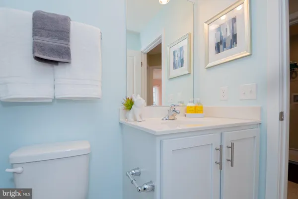 a bathroom with a sink a toilet and painting on the wall