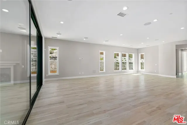 a large kitchen with stainless steel appliances granite countertop a large counter top and a wooden floor