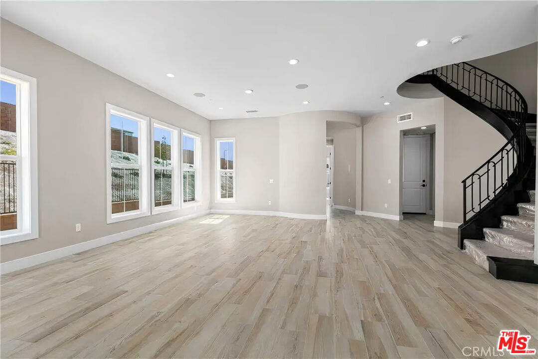 20517 Deer Grass Court Porter Ranch, CA 91326 - Photo 18 of 75 a view of an empty room with wooden floor and windows