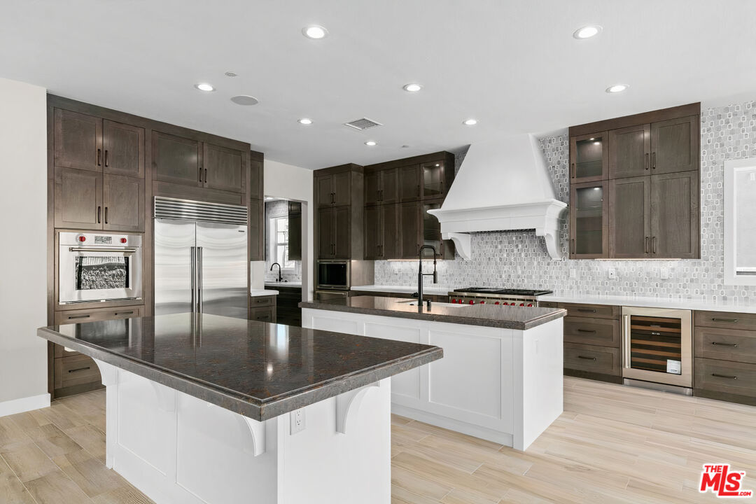 20517 Deer Grass Court Porter Ranch, CA 91326 - Photo 22 of 75 a kitchen with stainless steel appliances granite countertop a sink microwave and cabinets