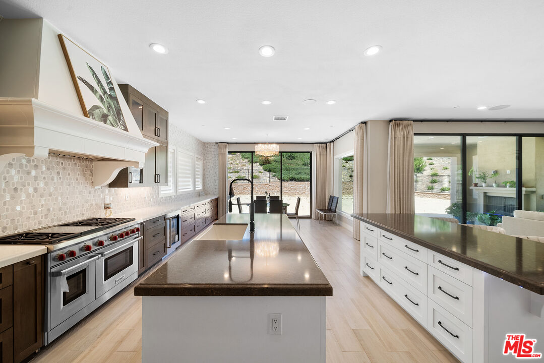 20517 Deer Grass Court Porter Ranch, CA 91326 - Photo 24 of 75 a kitchen with stainless steel appliances granite countertop a stove and a sink