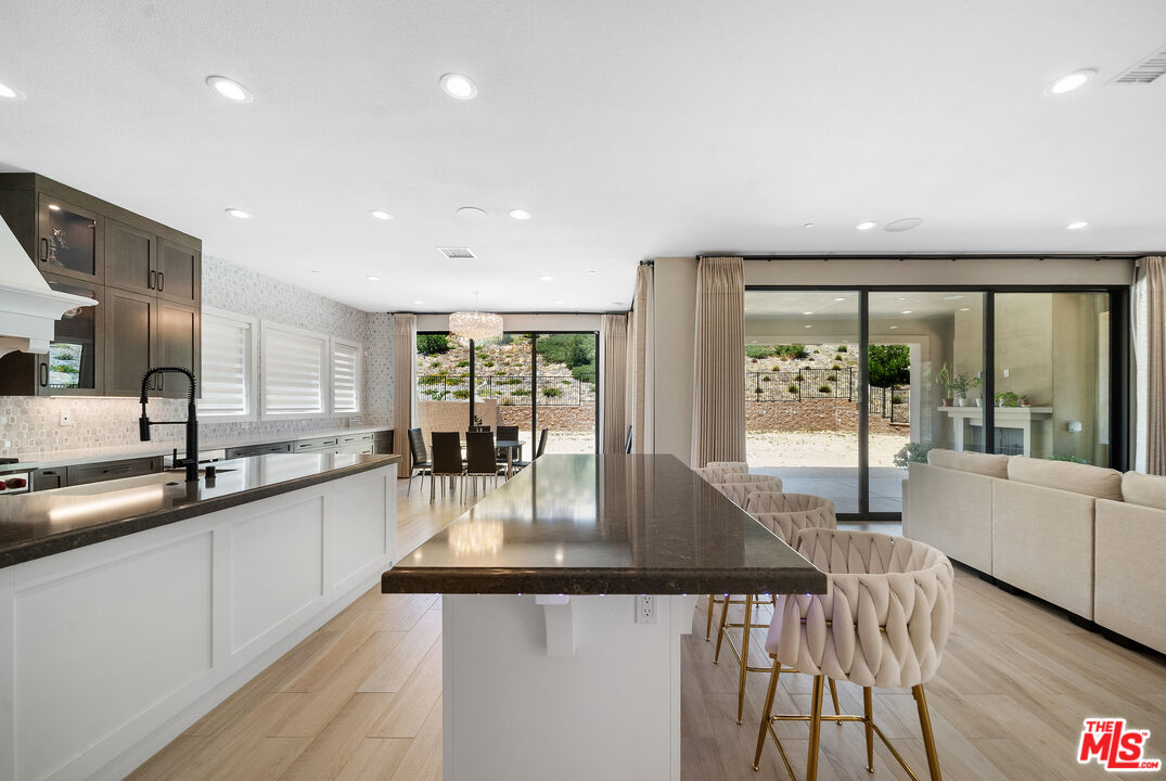 20517 Deer Grass Court Porter Ranch, CA 91326 - Photo 25 of 75 a kitchen with stainless steel appliances granite countertop a sink a counter top space and living room view