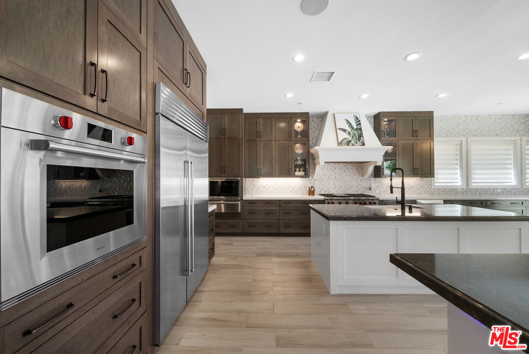 20517 Deer Grass Court Porter Ranch, CA 91326 - Photo 27 of 75 a large kitchen with stainless steel appliances kitchen island granite countertop a stove and a sink