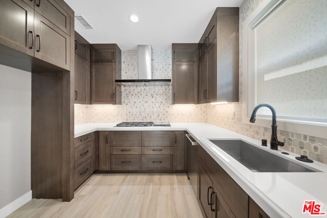 20517 Deer Grass Court Porter Ranch, CA 91326 - Photo 32 of 75 a kitchen with stainless steel appliances granite countertop a sink stove and refrigerator
