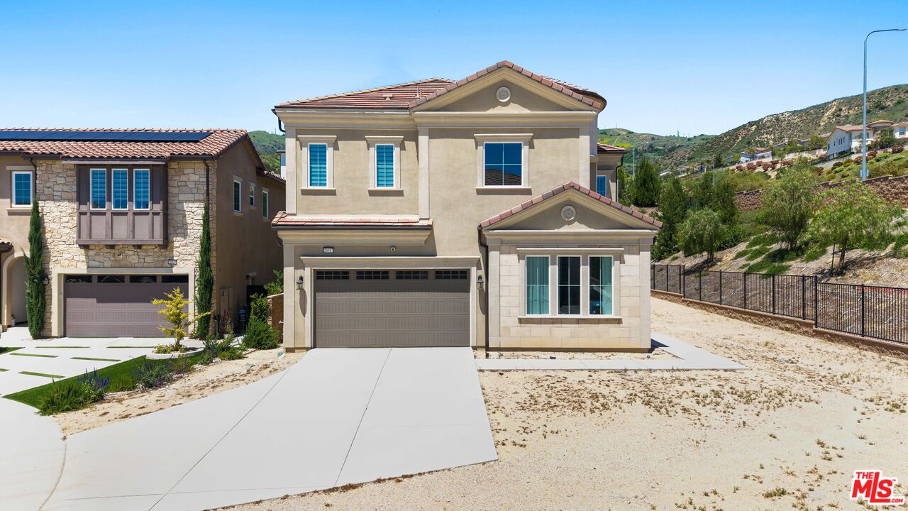 20517 Deer Grass Court Porter Ranch, CA 91326 - Photo 4 of 75 a front view of a house with a yard and garage