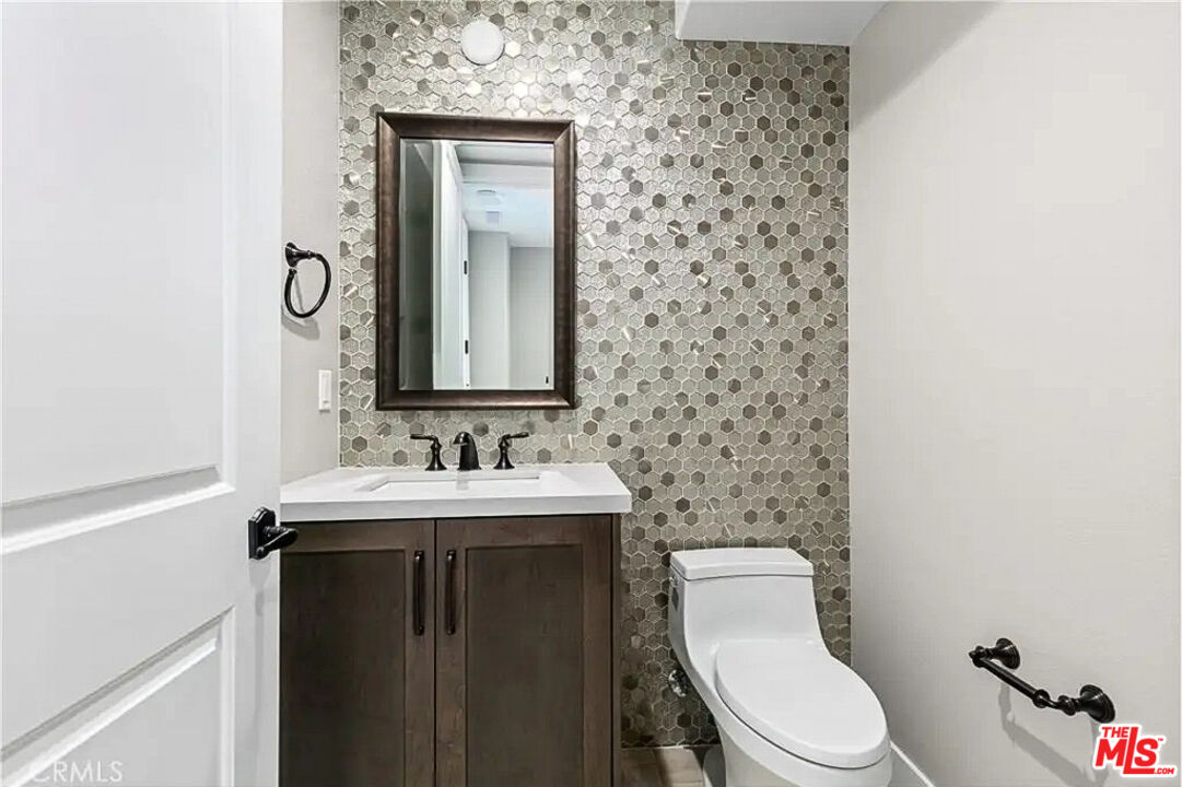 20517 Deer Grass Court Porter Ranch, CA 91326 - Photo 56 of 75 a bathroom with a toilet a sink and mirror