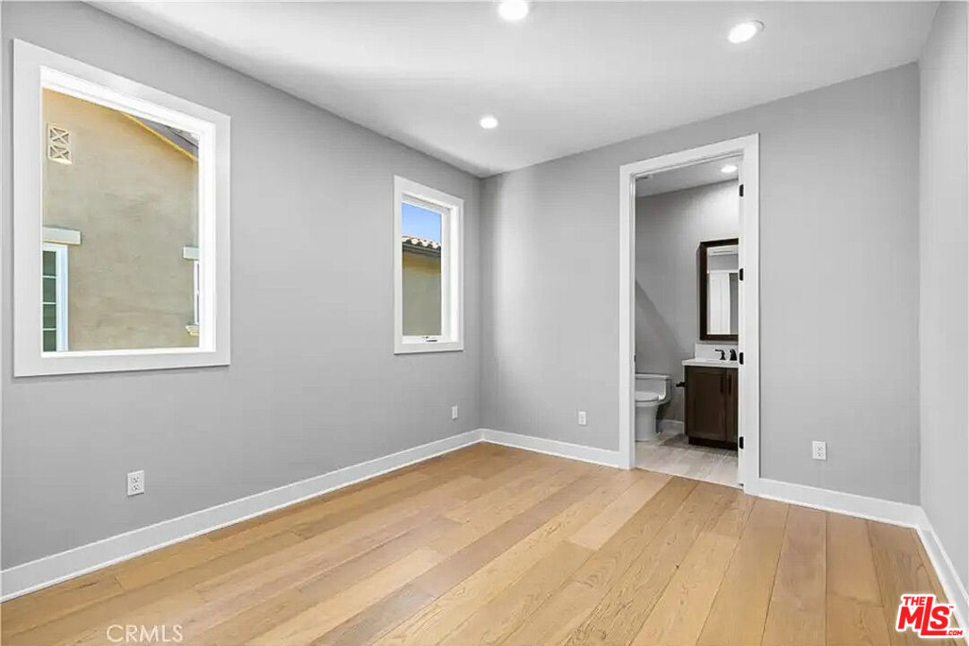 20517 Deer Grass Court Porter Ranch, CA 91326 - Photo 59 of 75 a view of an empty room with wooden floor and a window