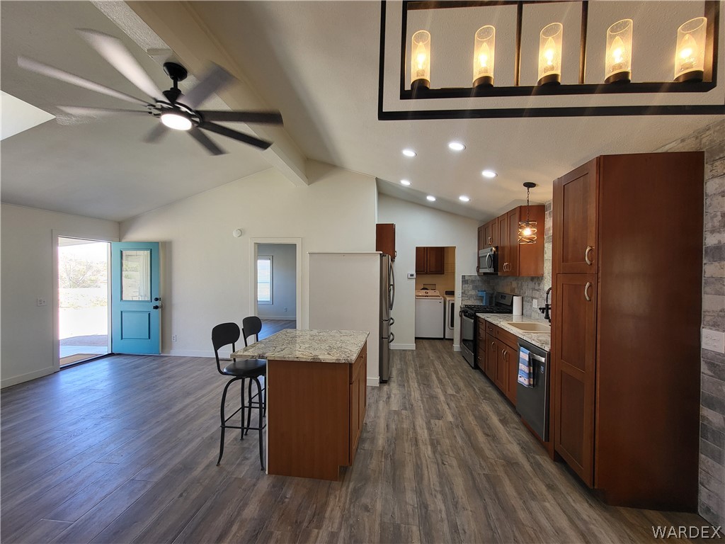 30260 Haystack Drive Meadview, AZ 86444 - Photo 11 of 52 a kitchen with stainless steel appliances kitchen island granite countertop wooden floors and a refrigerator