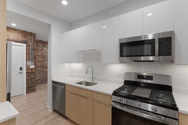 a kitchen with stainless steel appliances a sink a stove and microwave