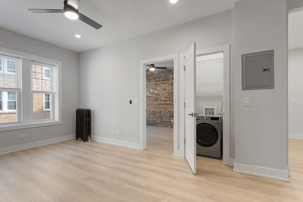 a view of a big room with wooden floor cabinet and windows