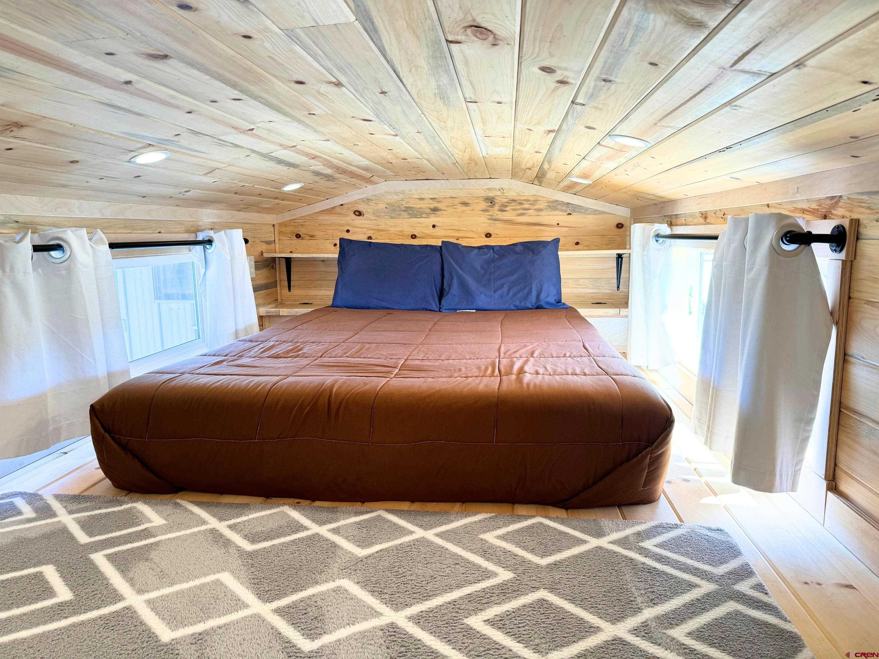 22130 6850 Road, Unit 214 Montrose, CO 81403 - Photo 16 of 26 a bedroom with a bed and a walk in closet