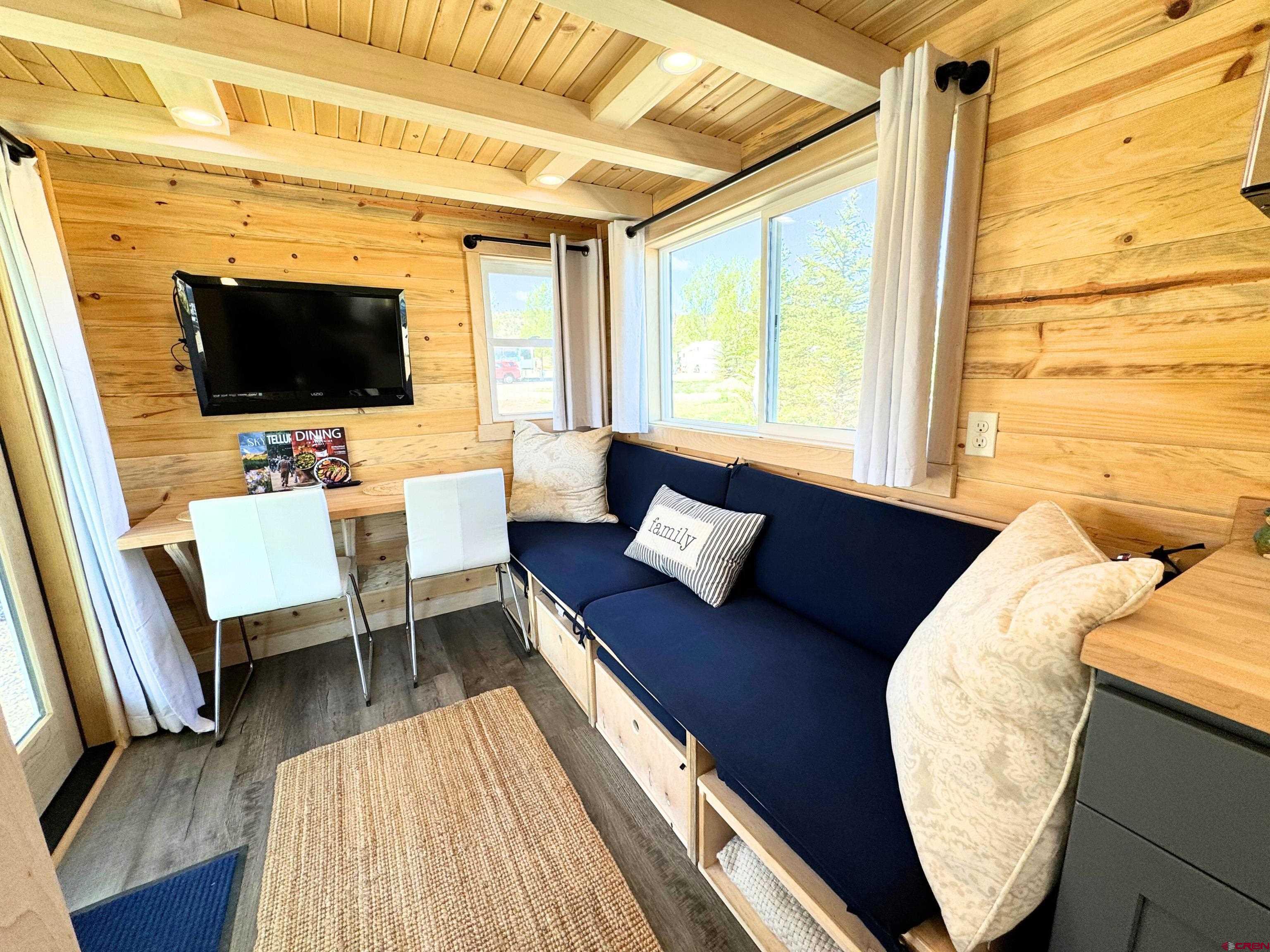 22130 6850 Road, Unit 214 Montrose, CO 81403 - Photo 2 of 26 a living room with a couch and a flat screen tv