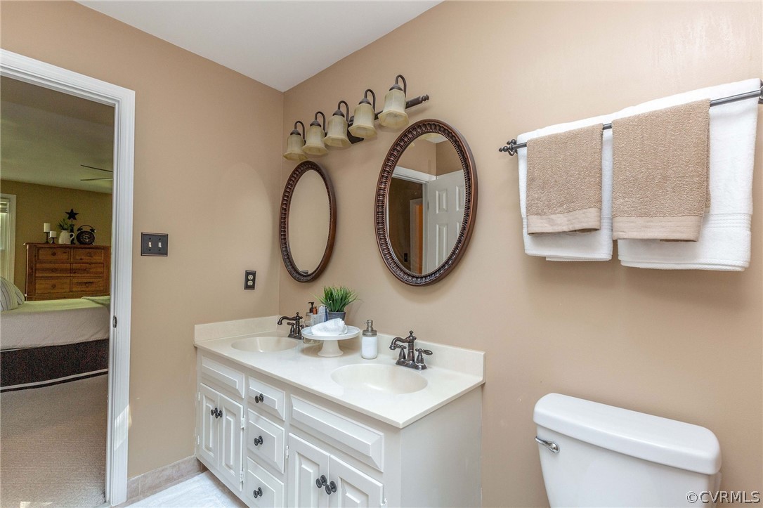 14302 Huntgate Woods Road Midlothian, VA 23112 - Photo 34 of 50 a bathroom with a toilet a sink a mirror and a bathtub