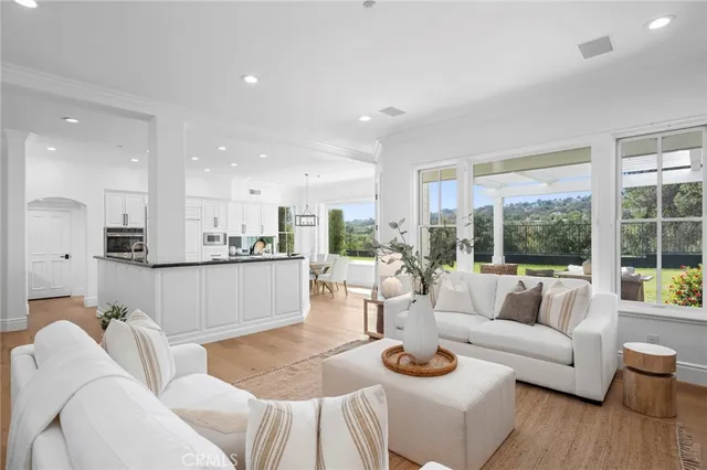 a living room with furniture kitchen and a large window