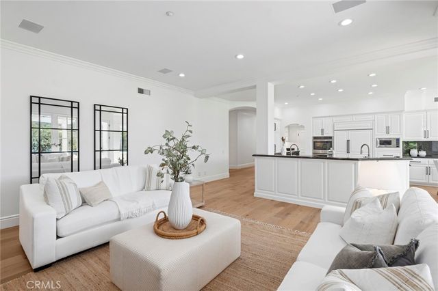 an open kitchen with granite countertop a sink and white cabinets