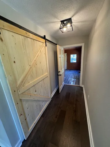 a backyard of a house with large trees and brick wall