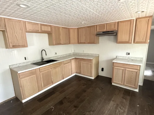 a kitchen with a sink cabinets and wooden floor