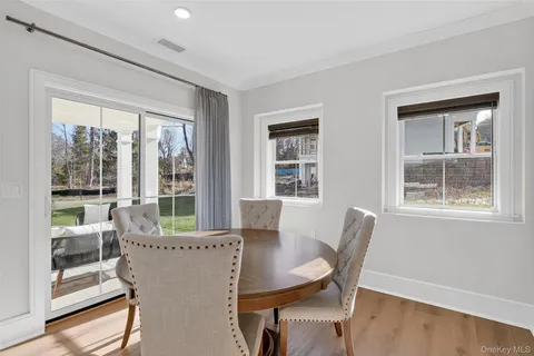 a view of a dining room with furniture large windows and wooden floor