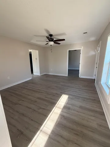 a view of a livingroom with a ceiling fan and wooden floor