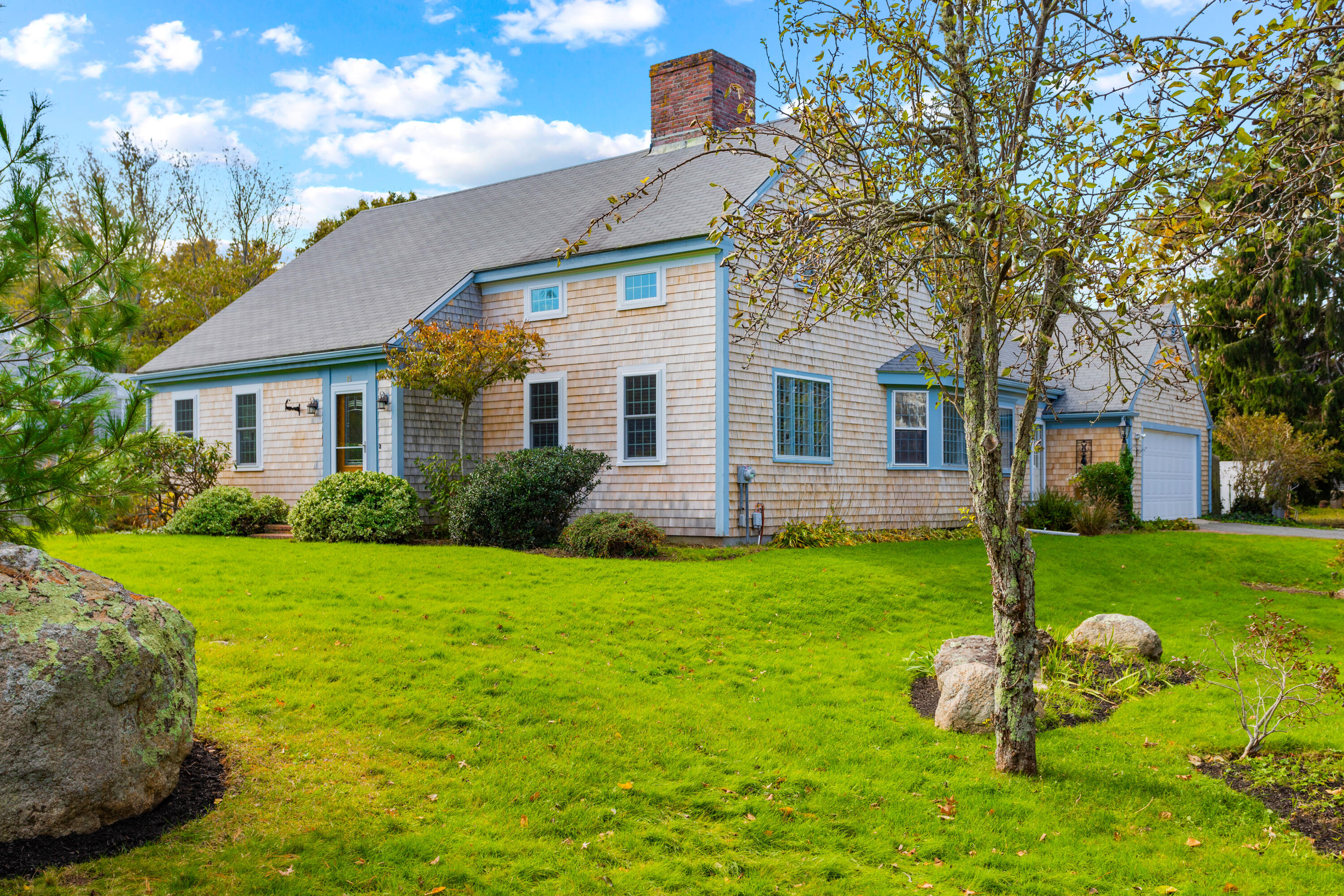 a front view of a house with a yard and trees