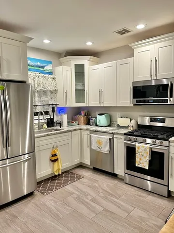 a kitchen with granite countertop a refrigerator stove and microwave
