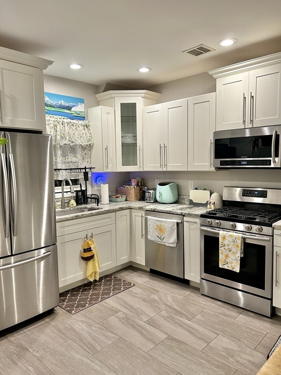 6 Florence Street, Unit 2 Somerville, MA 02145 - Photo 2 of 8 a kitchen with granite countertop a refrigerator stove and microwave