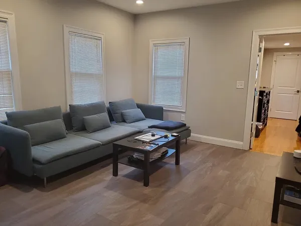 a living room with furniture and a wooden floor